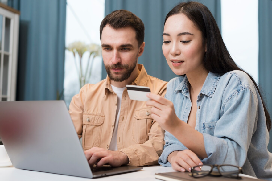Couple reviewing a credit card while discussing authorized user credit score impact decisions.