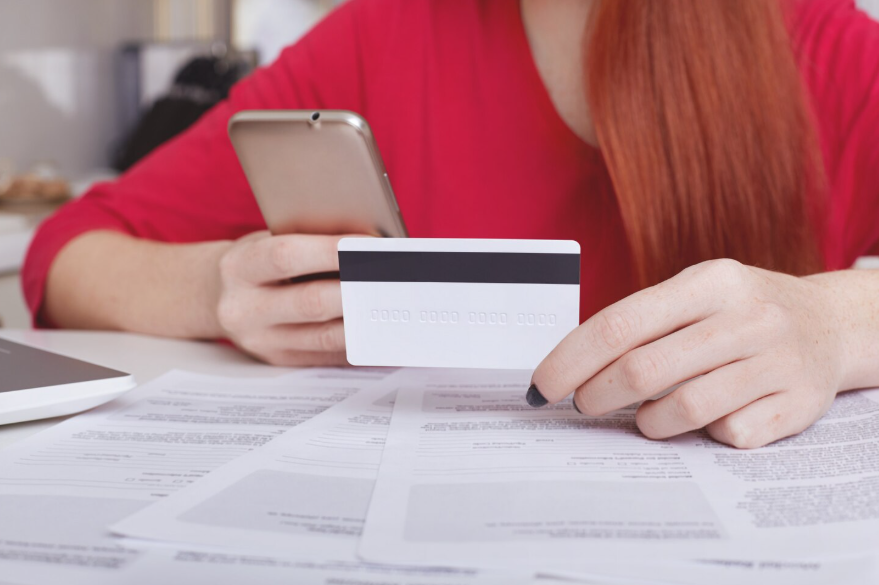 Person reviewing financial documents and credit card while learning how to read a credit report