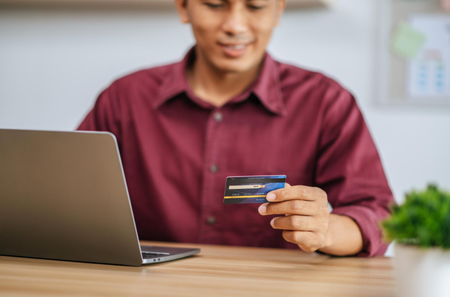 Person reviewing a credit card online while deciding if closing a credit card hurt score.